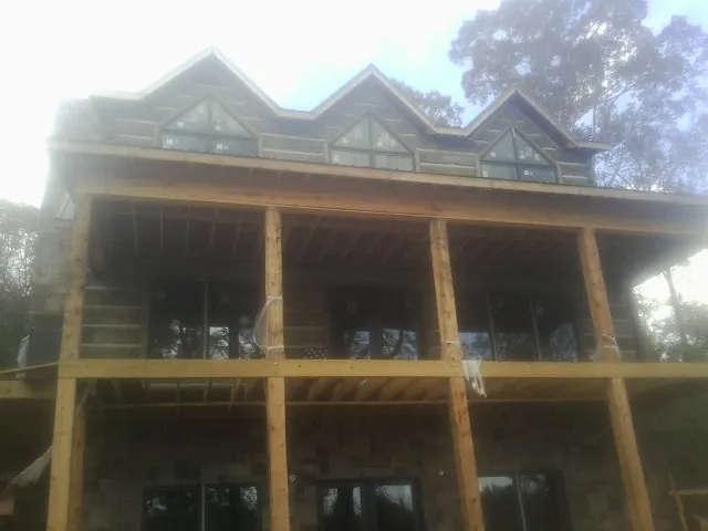 Dormers and porch framing on a large log home under construction — Roof Coating work by our crew in Stirling City