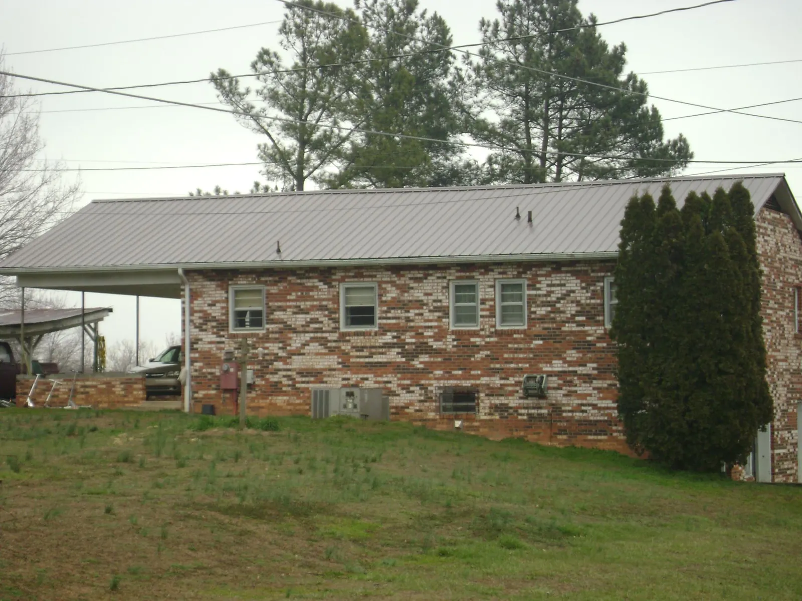 Gray metal roof on a brick split level home with a carport in Stirling City